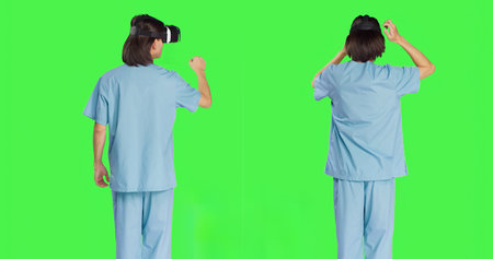 Medical personnel uses virtual reality eyewear against greenscreen set while using new interactive 3D headpiece. Clinical healthcare specialist using artificial intelligence vision.の写真素材