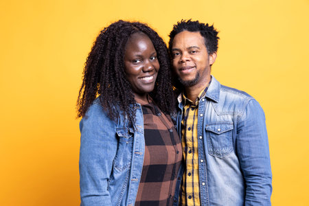 African american romantic couple smiling and posing next to each other, being in love and showing...