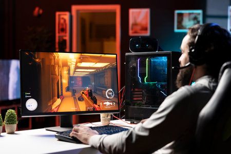Pro gamer wearing headphones competing in intense online multiplayer videogame, shooting enemies...