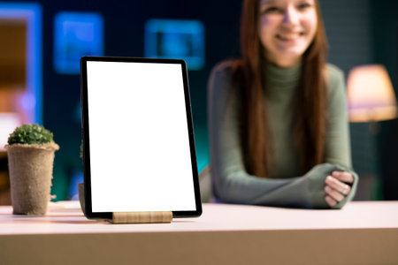Focus on mockup tablet presented by joyful girl in blurry background. Close up shot of isolated...