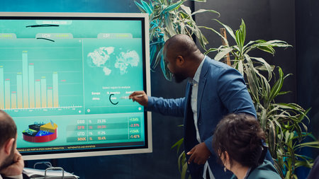 Startup team analyzing worldwide sales and client feedback, using interactive boar to examine revenue and funds. Coworkers developing brand differentiation strategies for profit growth. Camera A.の写真素材