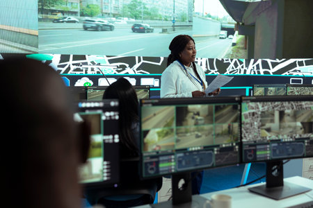 African american supervisor offers shipment information for delivery parcels to her team, employees...