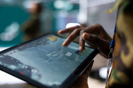 Trooper inspecting the national territory via radar surveillance footage, using a tablet to detect any danger in command center control room. Soldier working in defense army division. Close up.の写真素材