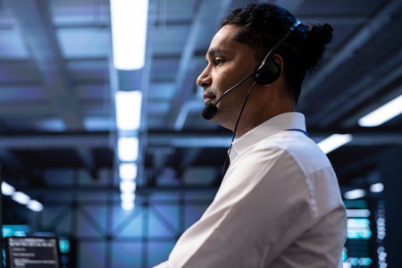 IT specialist in data center providing technical support to customers, troubleshooting issues, close up. Server farm worker carrying out operational technical interventions requested by clientsの写真素材