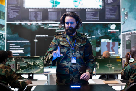 Young soldier collecting battlefield data and details for a new mission, employing a hologram projection in monitoring room. Recruit examines briefings on 3d holographic visualization.の写真素材