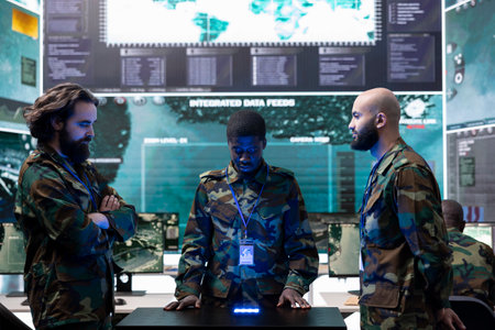 Team of diverse soldiers conducting intelligence gathering activity, studying footage on a hologram projection to help infantry units in the field. Trained troopers collect real time data.の写真素材
