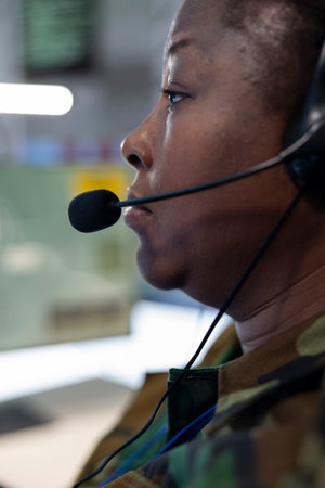 Trained woman engineer monitoring federal surveillance system in army power base, working with a big...