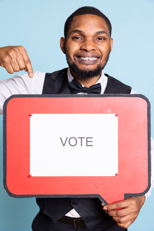 Professional front desk staff presenting a red speech bubble with a vote message. Hotel personnel showing the billboard icon for an ad commercial.の写真素材