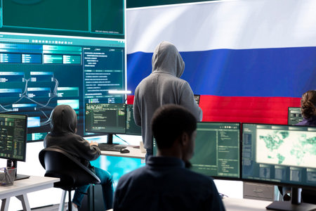 A hacker working in a governmental IT workspace with the USA flag running on big screen. Ensuring cybersecurity, cyber threat analysis and global surveillance to ensure cyber protection.の写真素材