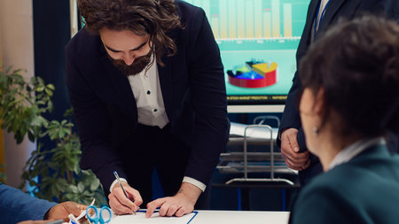 Business administrators shaking hands and signing a new contract, starting fruitful collaboration...