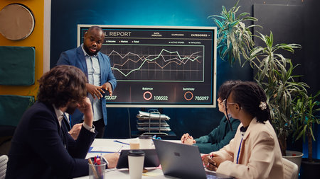 Digital marketing team attending an innovation and brainstorming meeting in boardroom, analyzing sales reports to understand market trends. Working on enterprise growth solutions. Camera B.の写真素材