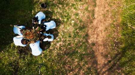 Aerial view of volunteers participate in nurturing the ecosystem, planting trees, raising sprouts and tidy up surroundings. Eco friendly activists maintaining the natural forest habitat.の写真素材