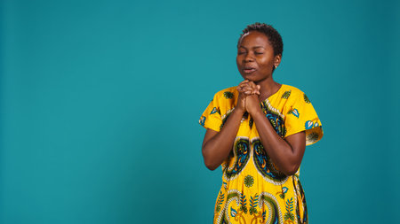 Cheerful young woman feeling pleased and satisfied with something, clapping her hands and showing optimistic emotions. Happy person in traditional ethnic clothing with native elements.の写真素材