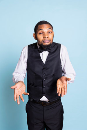 Undecided clueless man with suit and tie shrugging in studio, showing uncertainty and symbol. Doubtful man acting unsure and confused, sceptic staff.の写真素材