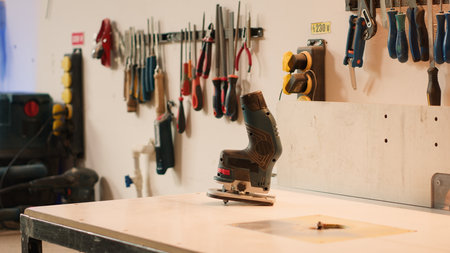 Close up of electric router on wood shaper in carpentry studio used for precision cutting of wood blocks. Focus on power tool on spindle moulder used in woodworking, panning shotの写真素材