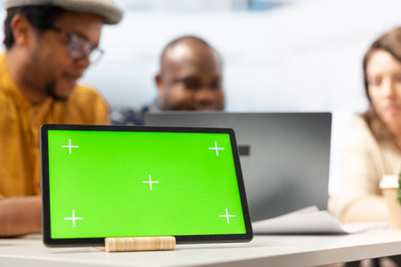 Real estate expert negotiating contract terms with clients next to mockup display, reviewing architectural blueprints for relocation in high class office space. Realtor shows investment possibility.の写真素材