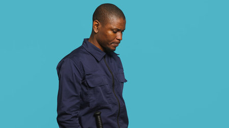 Cheerful security guard celebrating achievements during protection job shift. Portrait of joyous bodyguard feeling satisfied after completing tasked orders, studio background, camera Aの写真素材