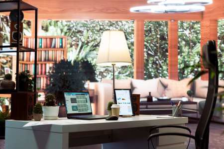 Empty home office belonging to a small business owner with data sales reports on laptop, annual information and invoices for accounting work. Finance and economy budget balance.の写真素材