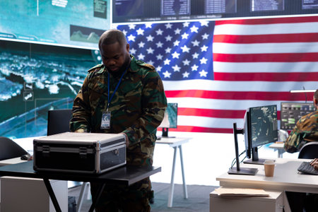 Military personnel team in a high tech command center examining cctv surveillance footage, control surveillance systems and protect sensitive data. American soldiers ensuring national security.の写真素材