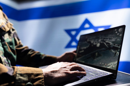 IDF army soldier using laptop, operating anti ballistic system designed to counter missiles threatening country. Close up of Israeli intelligence corps officer defending nation against rocketsの写真素材