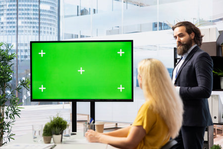 Financial adviser conducting audit of clients income, doing presentation on green screen to help them build saving habits. Agent using large mockup display to show investing tipsの写真素材