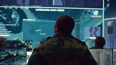 Female technical sergeant monitoring air traffic to detect any enemy aircraft, working in federal reconnaissance system to ensure national safety. Woman officer uses big screen and gear. Camera B.の写真素材