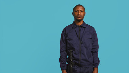 Security guard tasked with preventing criminal activity and detaining suspects stealing, damaging property, or performing other crimes. Portrait of intimidating bodyguard, studio background, camera Bの写真素材