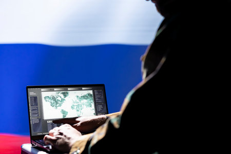 Russian ex KGB FSB operative engaged in surveillance mission using laptop, looking at world map. Intelligence officer isolated over Russia flag working for Kremlin regime monitoring zone of interestの写真素材
