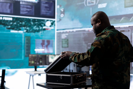 Army espionage specialist in a control center collecting satellite cctv data real time surveillance, supporting strategic military operations. Working to ensure national security and protocols.の写真素材