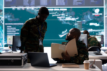 Military experts in an operations center handle satellite data details, overseeing live surveillance for reconnaissance activity. Intelligence operations to support strategic military missions.の写真素材