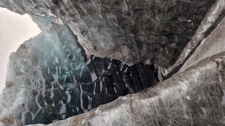 Ice caves with iceberg blocks at vatnajokull in iceland, inside massive frosty crevasse with transparent cracked ice cap. Spectacular icy mass glacier in wintry frozen landscapes.の写真素材