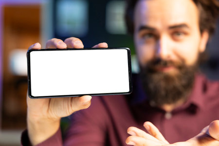 Close up shot of isolated screen smartphone in man hand using it as empty copy space to showcase his...