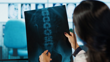 Indian female specialist explains diagnosis through test findings with a young man in medical...