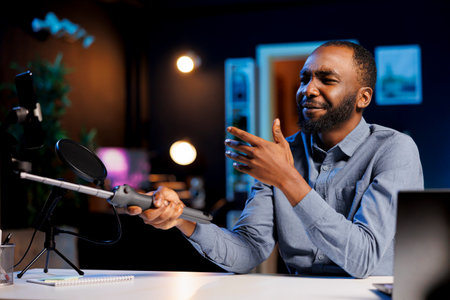 Media star reviewing selfie stick, expressing dissatisfaction with subpar quality of materials used. Content creator shooting video for online channel, displeased with low quality mobile phone holderの写真素材