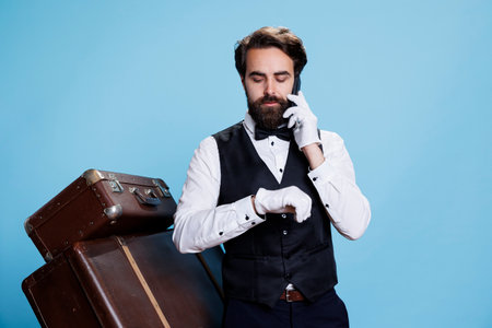 Hotel concierge answers phone calls and makes reservations over the telephone. Skilled elegant bellhop provides excellent assistance including remote communication and bookings.の写真素材