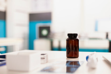 pill container and x-ray in focus on medical office desk. Closeup of prescription bottle and diagnostic image positioned on table of empty clinic.の写真素材
