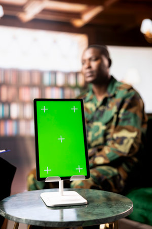 African american serviceman next to green screen suffering from post traumatic stress disorder after combat, attends therapy session with psychologist. Infantry officer deals with shell shock.の写真素材