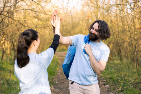 Happy man and woman sharing high five gesture and praising each other, pleased about finishing...