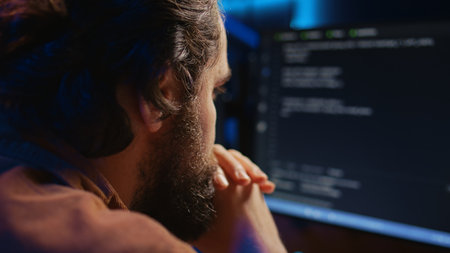 Programmer in home office concentrating on finding bugs while doing coding on computer, extreme...