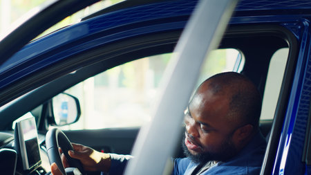 Client doing thorough car test drive, making sure he feels comfortable and enjoys driving vehicle. Customer trying out new automobile before purchase, to see if it is right for his needs, camera Aの写真素材