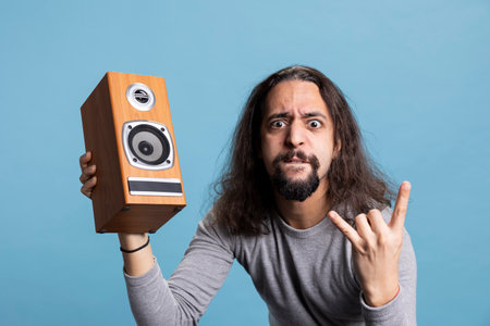 Dynamic musician listening to heavy metal music on a loud speaker, full of energy and passion...