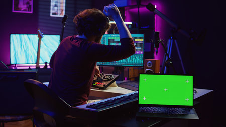 Musician mixing and mastering sounds at home studio with electronic console and soundboard, creating...