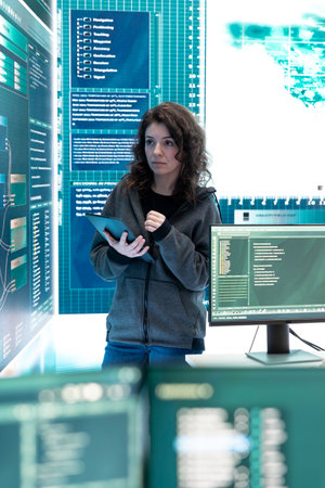 Cyber security expert investigates governmental hacking malware attack on big screen, high tech center. Cybercriminal woman hacks computer systems, threatening database protection.の写真素材