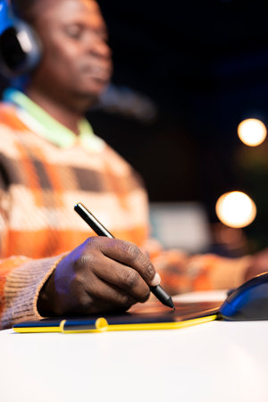 Skilled male designer using editing software on dual monitors in organized modern workspace, symbolizing the future of digital design and remote work. Digital art photo retouching.の写真素材