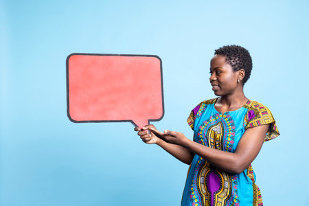 Stylish woman holding speech bubble sign to create an advertisement, creating a web commercial with...