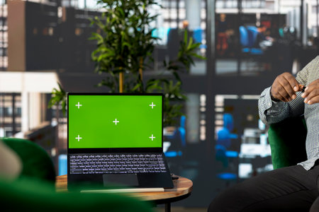Startup CEO attends meeting to talk about new business vision with executive board member, using green screen laptop. Employee using mockup notebook to pitch investment strategy to managerの写真素材