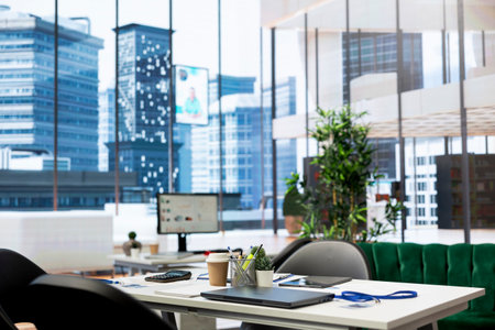 Empty financial department office used for budgeting, forecasting, and financial analysis purposes. Bright modern company workspace with nobody in and devices left open on desksの写真素材