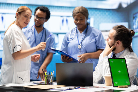 Diverse team of medics analyze x rays next to mockup copy space and discuss treatment plans in a...
