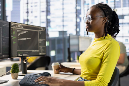 Back end developer managing cloud computing resources and platforms to train machine learning models. IT specialist monitoring and maintaining company systems, checking code on PC monitorの写真素材