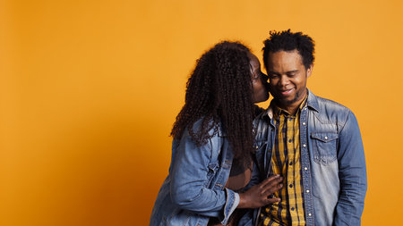 Funny wife making her husband laugh about sweet nothings, whispering things into his ear and amusing...